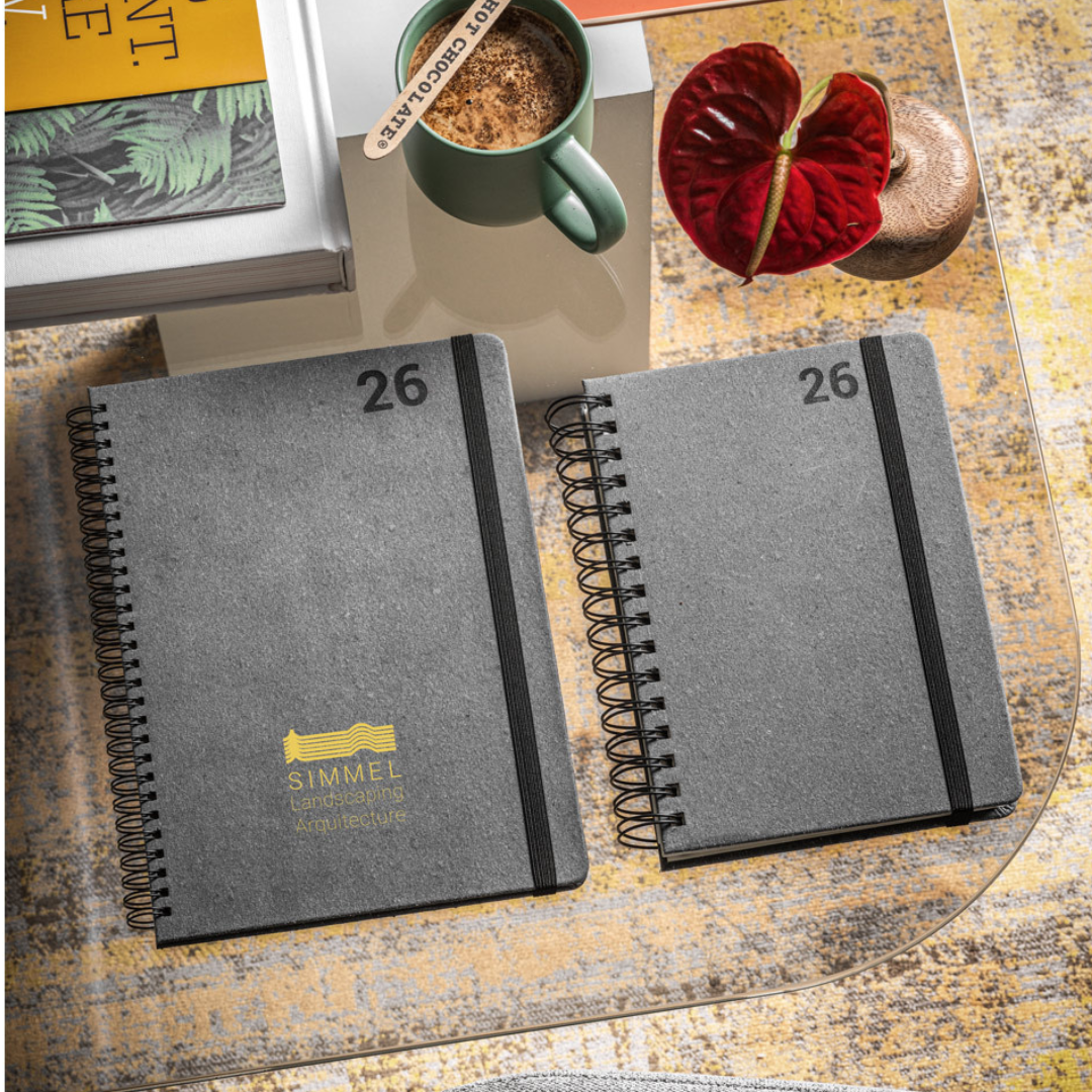 Agenda corporativa sostenible con cierre elástico y diseño profesional, fabricada con materiales reciclados y papel certificado FSC™.